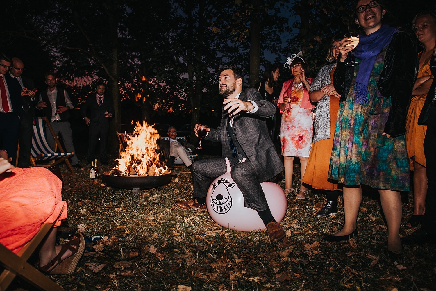 groom bouncing on space hopper by firepit at Stanlake Park
